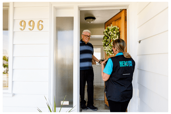 photo of a care nurse and elderly man discussing health needs