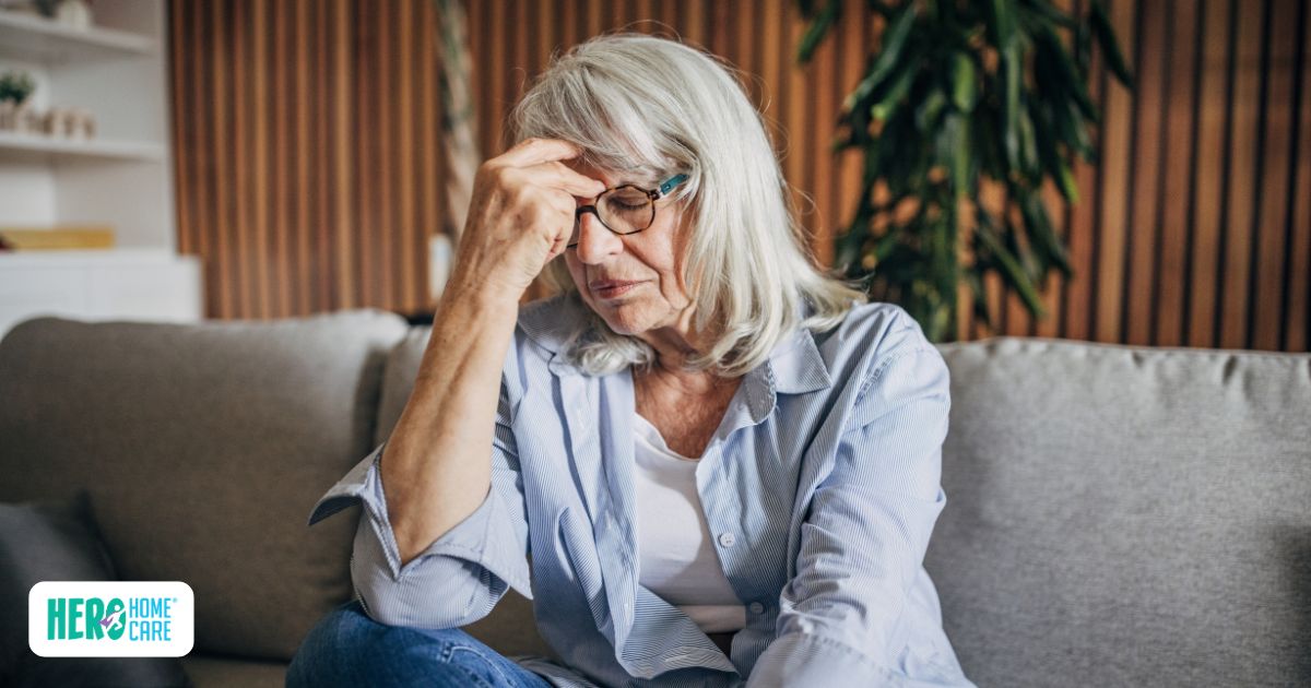 Senior woman with hand on forehead appearing stressed about accepting home care support