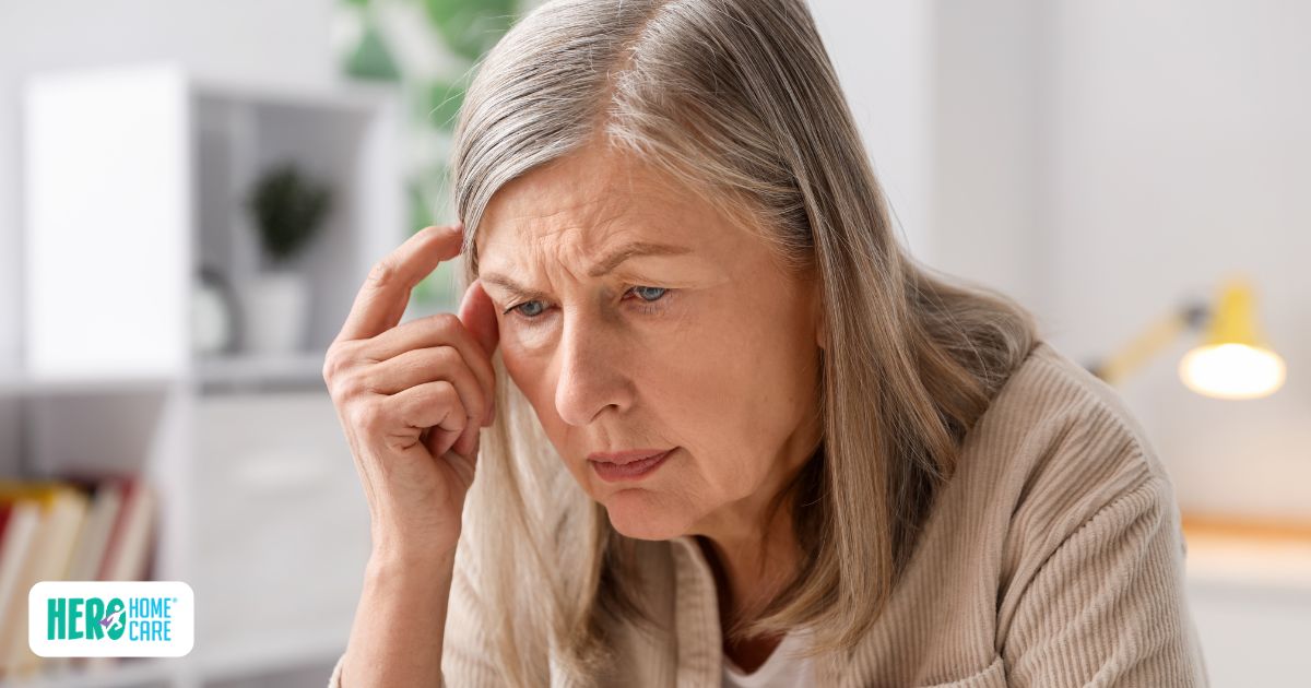 An elderly woman looks down with a concerned and confused expression, representing the early warning signs of dementia.