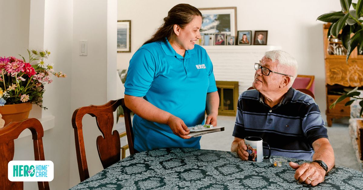 Hero Home Care caregiver assisting elderly man with daily medications at his dining table