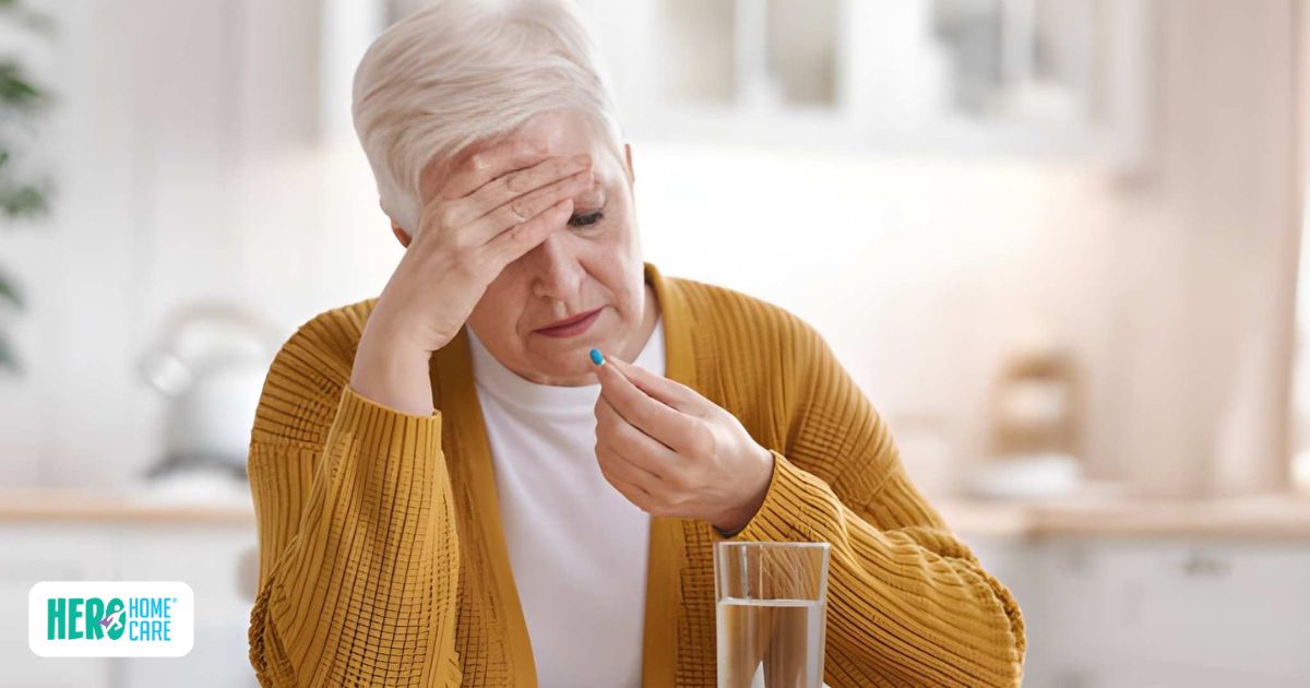 Older woman struggling with medication management, hand on forehead while holding a blue pill and water glass