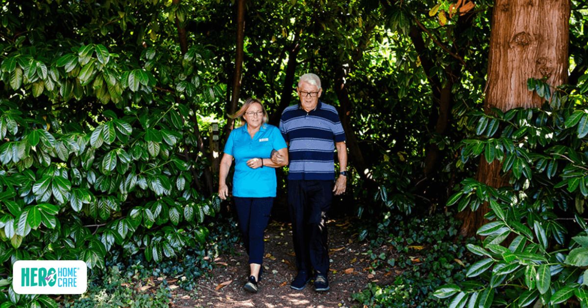 A caregiver supporting a senior on a walk, reflecting how gentle daily activity can help when an elderly parent is sleeping too much