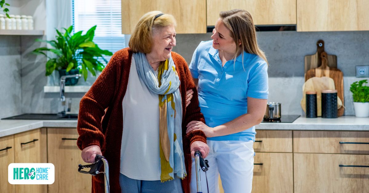 Senior using a walker while receiving mobility assistance from a caregiver at home, illustrating how older adults can recover safely at home instead of moving to an assisted living facility