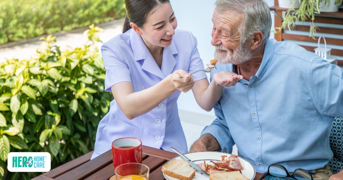 Senior with dementia enjoying breakfast with caregiver support, demonstrating a calm and predictable morning routine at home