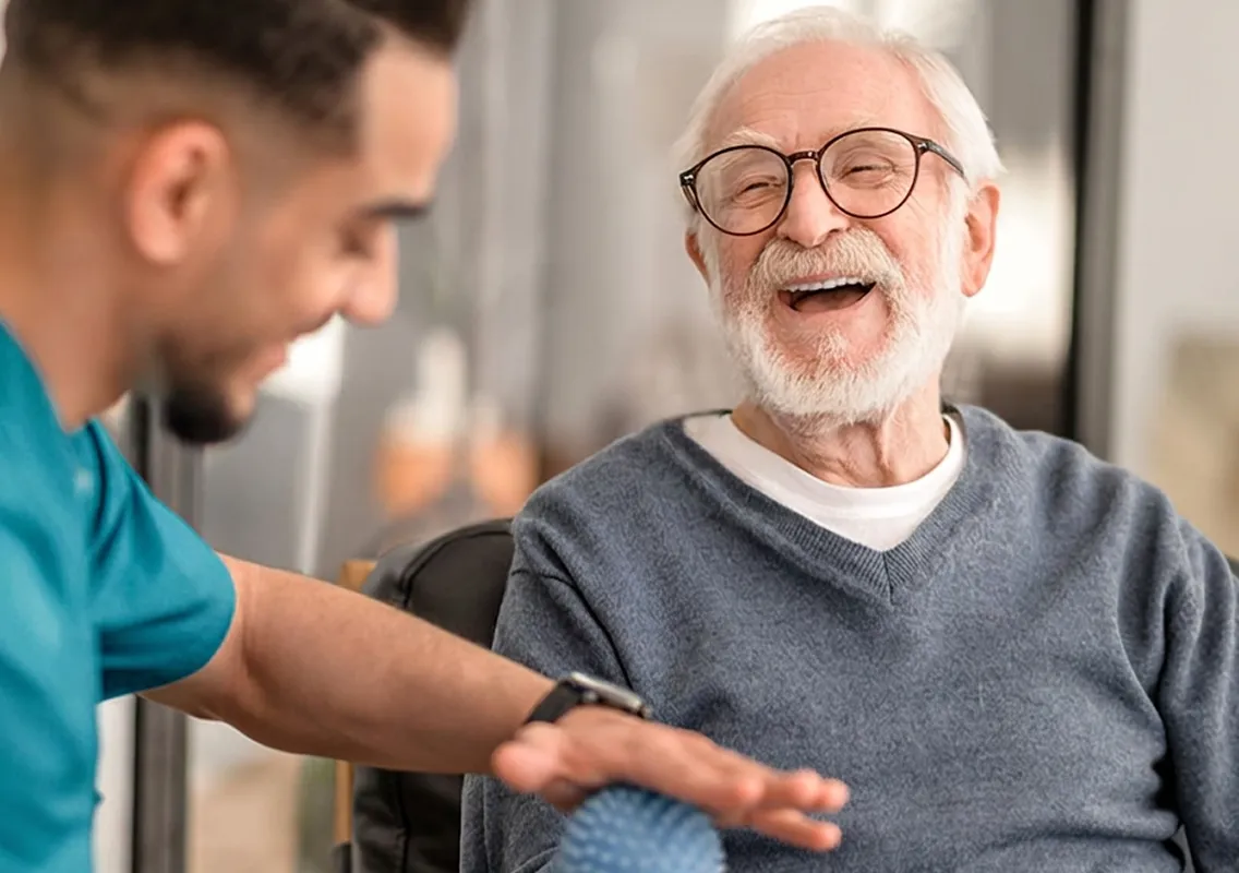 Caregiver assisting a senior with Parkinson's with dressing and grooming