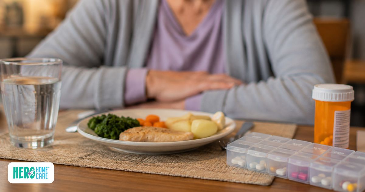 Older adult sitting in front of a meal and medications, illustrating how illness and medications can reduce appetite in later life.