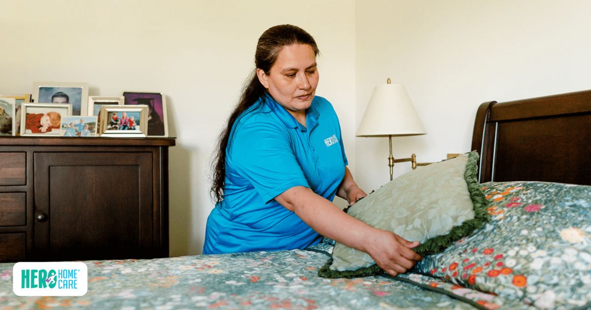 Hero Home Care caregiver preparing a senior's bedroom while providing personalized in-home care and daily living assistance.